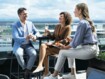 Drei Personen sitzen auf einer Dachterrasse und genießen einen Apperetiv