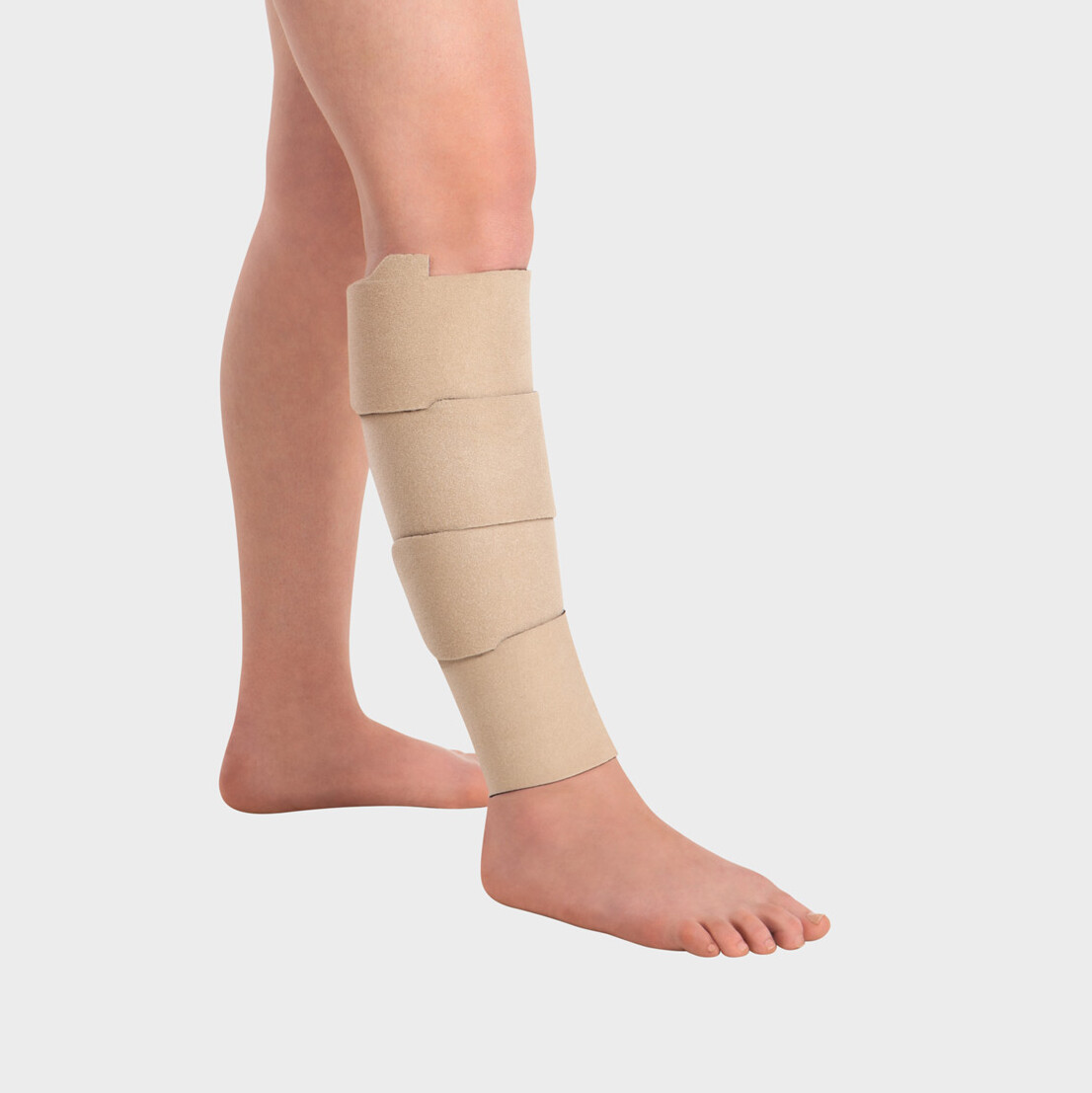 Persoon draagt Juzo Compression Wrap-Kuitstukken Persoon draagt Juzo Compression Wrap-Kuitstukken