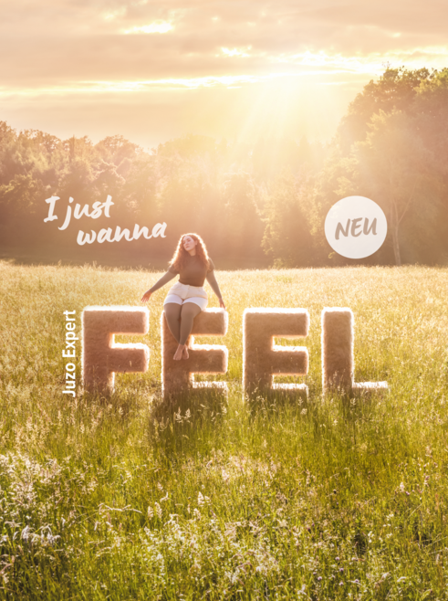 Eine Frau sitzt auf den Buchstaben "Feel" und trägt den Juzo Expert Feel