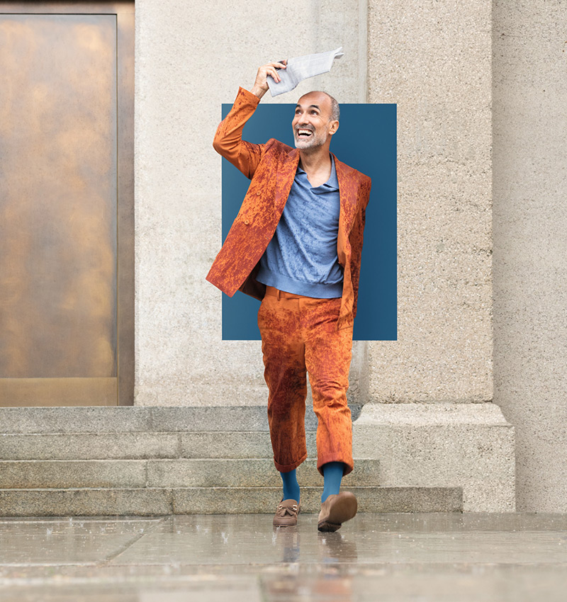A man is walking through the city in the rain. He is wearing compression socks in the trendy colour Casual Blue A man is walking through the city in the rain. He is wearing compression socks in the trendy colour Casual Blue