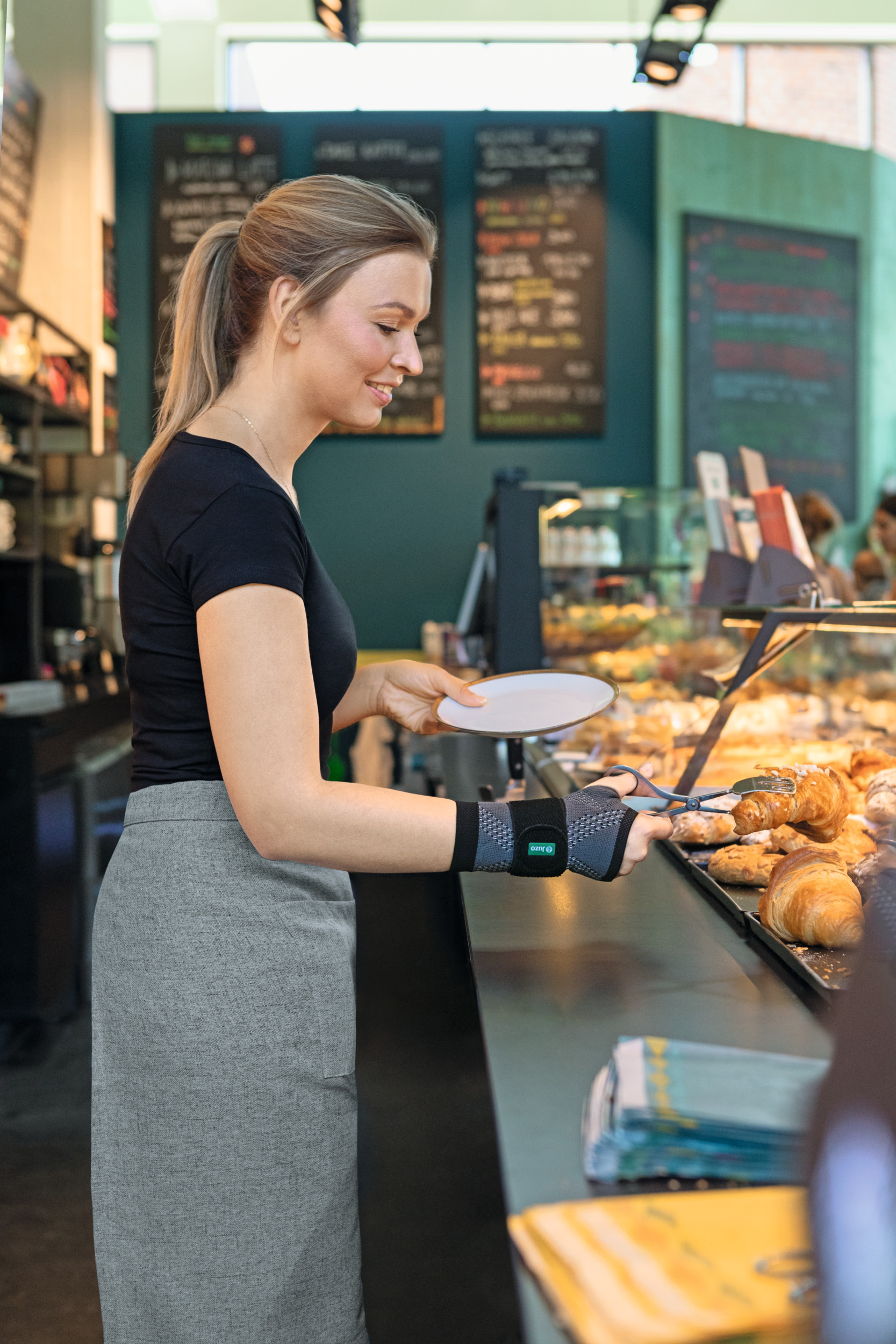 Une vendeuse spécialisée en boulangerie porte un bandage au poignet Une vendeuse spécialisée en boulangerie porte un bandage au poignet