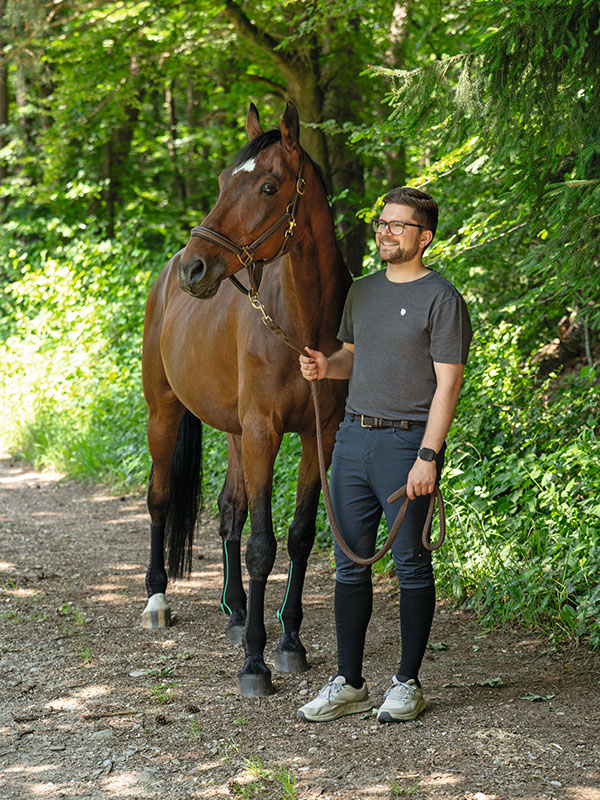 Equicrown Ein Mann steht neben einem Pferd