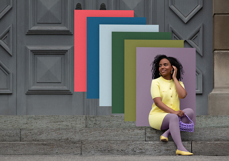 Juzo Trend Colours Batik Een vrouw zit op stenen treden voor een poort. Ze draagt een lichtgele tweedelige outfit met een paarse compressiekous. Achter haar zie je kleurvlakken in de trendkleuren.