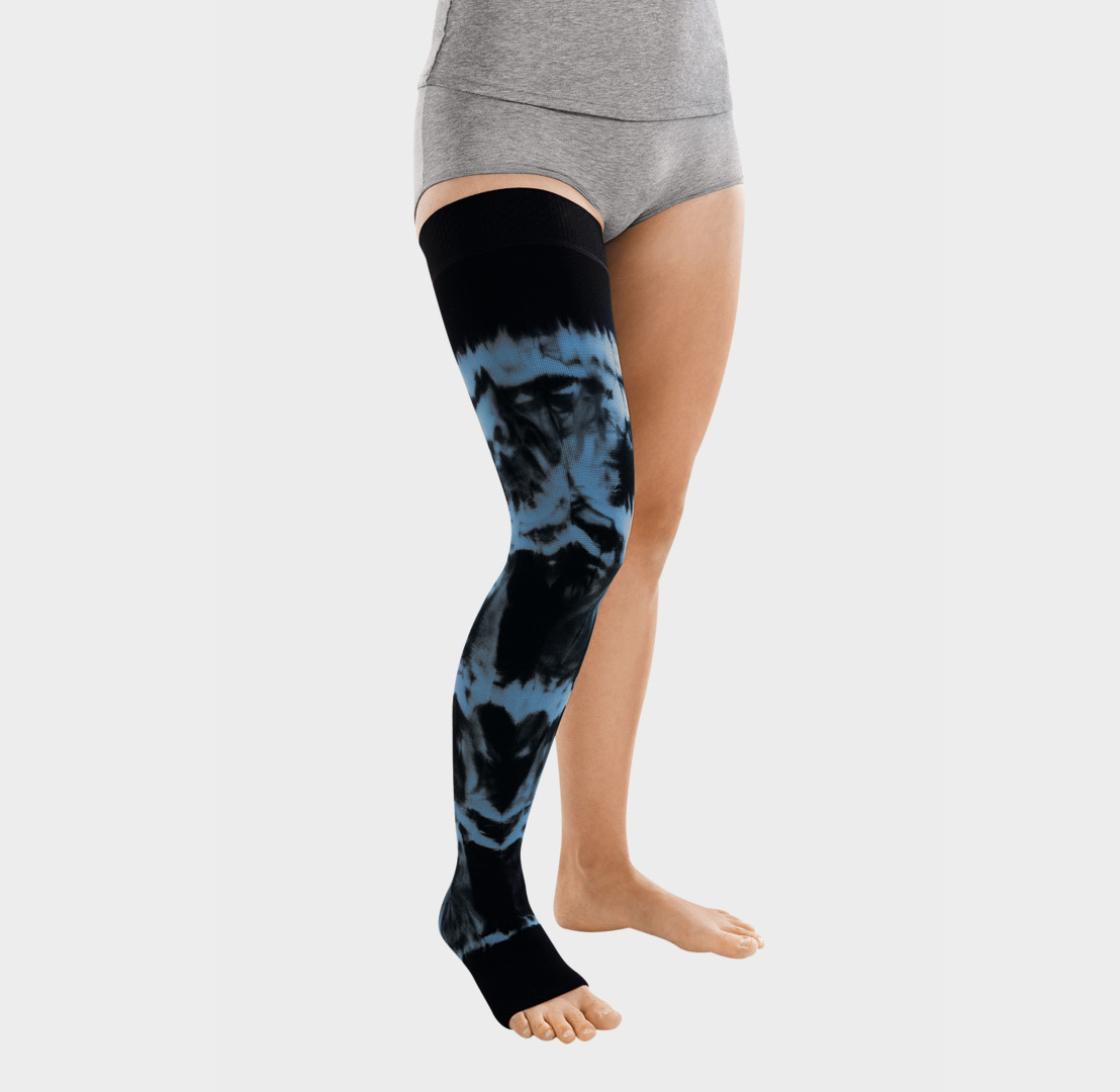 ScarComort Kompressionsstrumpf Schwarz-Blau Frau trägt einen schwarzen ScarComfort Fine Kompressionsstrumpf mit blauem Batik-Muster