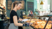 A bakery saleswoman wears a wrist bandage