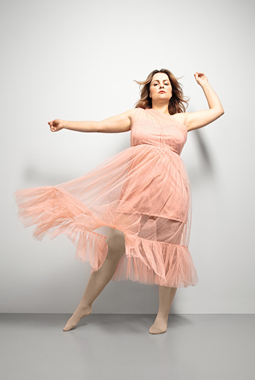 10. Lifestyle Bild Juzo Inspiration  Frau mit Juzo Inspiration und Strumpfhose in Mandel und rosanem Kleid