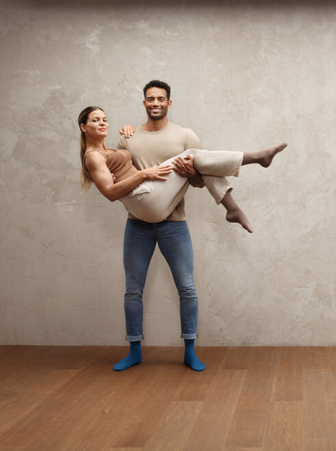 2. Lifestyle imagen Juzo Intenso Hombre con mujer en brazos, ambos llevan las medias Juzo Intenso