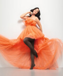 Image de style de vie Juzo Inspiration Femme avec Juzo Inspiration et collants en cacao et robe orange