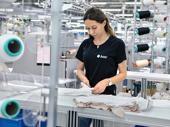 Mitarbeiterin in der Produktion prüft sorgfältig die Produkte