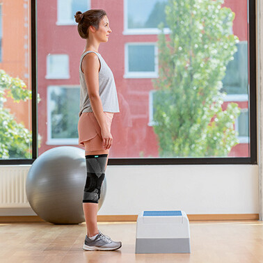 Frau steht vor Step-Aerobic-Brett