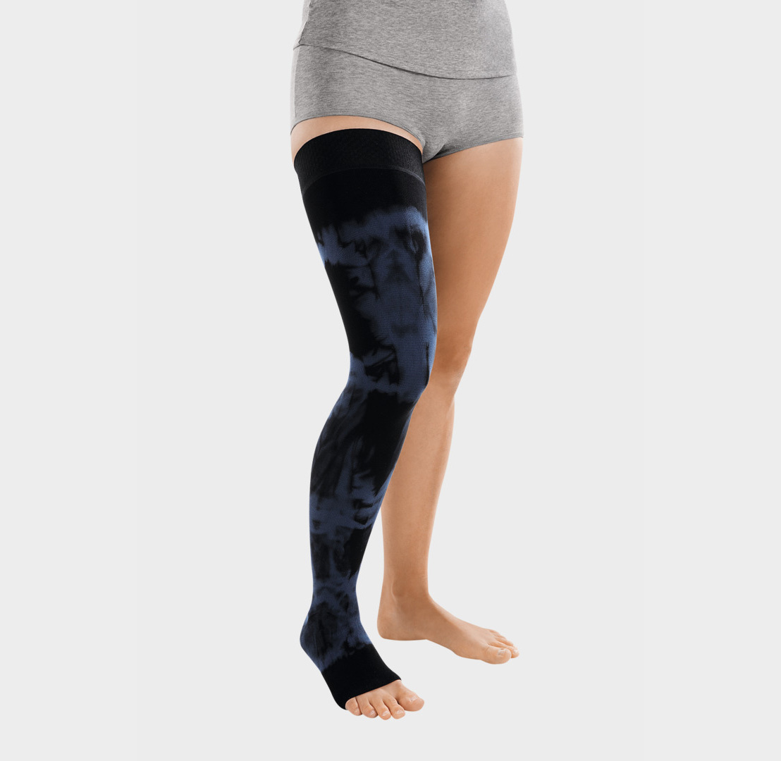 ScarComort Kompressionsstrumpf Schwarz-Dunkelblau Frau trägt einen scwarzen ScarComfort Fine Kompressionsstrumpf mit dunkelblauem Batik-Muster