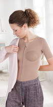 Woman with thorax compression vest is putting on a jacket