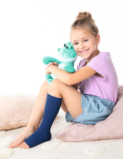 Mädchen mit Kompressionsstrumpf und Julius-Plüschtier