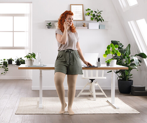 Uma mulher está na sala de estar, falando ao telefone