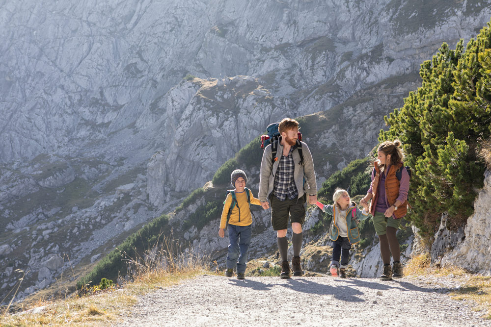 A family in the mountains. The parents are wearing compression stockings A family in the mountains. The parents are wearing compression stockings