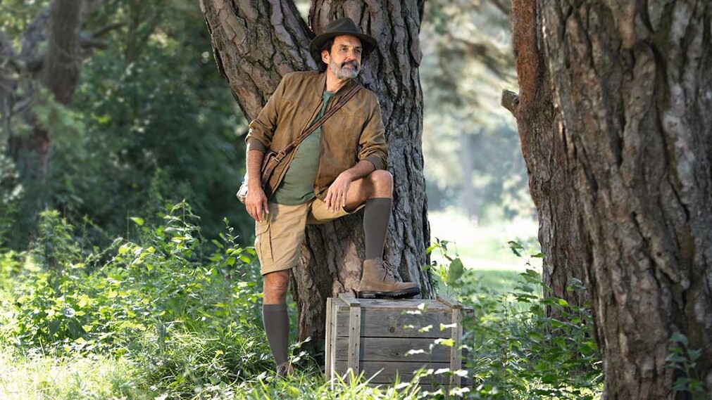 Un hombre vestido con ropa de explorador está en plena naturaleza y mira hacia el horizonte. Lleva medias de compresión que le llegan hasta las rodillas. Un hombre vestido con ropa de explorador está en plena naturaleza y mira hacia el horizonte. Lleva medias de compresión que le llegan hasta las rodillas.