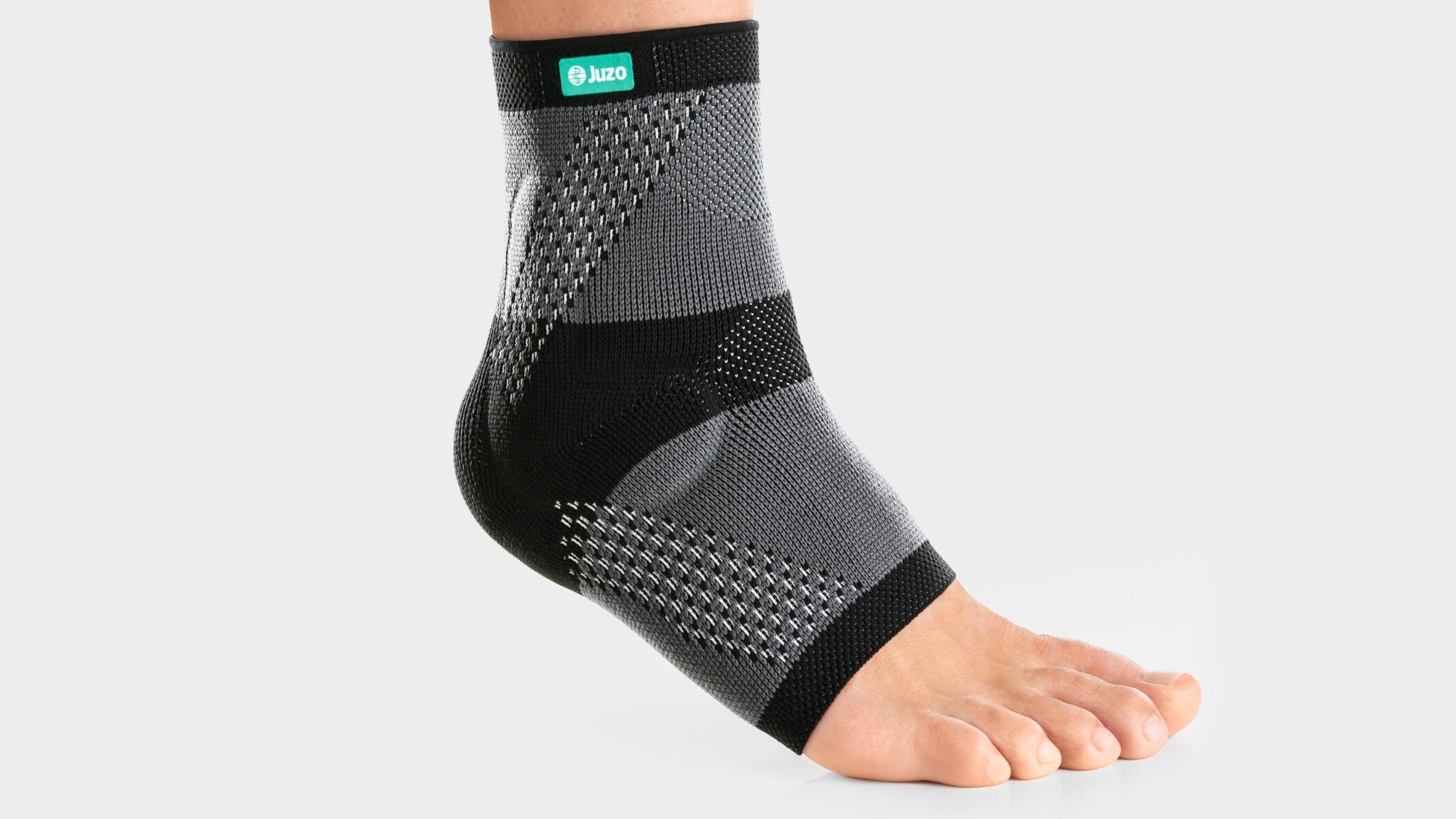 Jemand läuft über einen Feldweg und trägt dabei eine Sprunggelenkbandage
