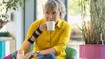 Woman wearing the JuzoPro Manu Xtec Palmar wrist orthosis holds a cup in her hand