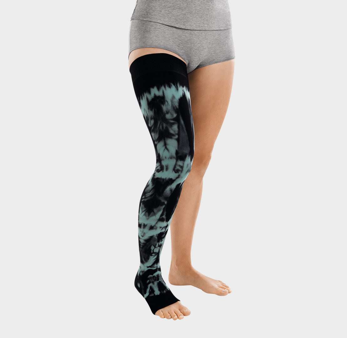 ScarComort Kompressionsstrumpf Schwarz-Mint Frau trägt einen schwrzen ScarComfort Fine Kompressionsstrumpf mit mintfarbenem Batik-Muster