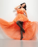 Lifestyle image Juzo Inspiration Woman with Juzo Inspiration and tights in cocoa and orange dress