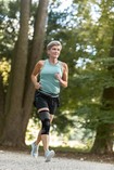 Biegająca kobieta ma na sobie ortezę stawu kolanowego JuzoPro Patella Xtec Plus