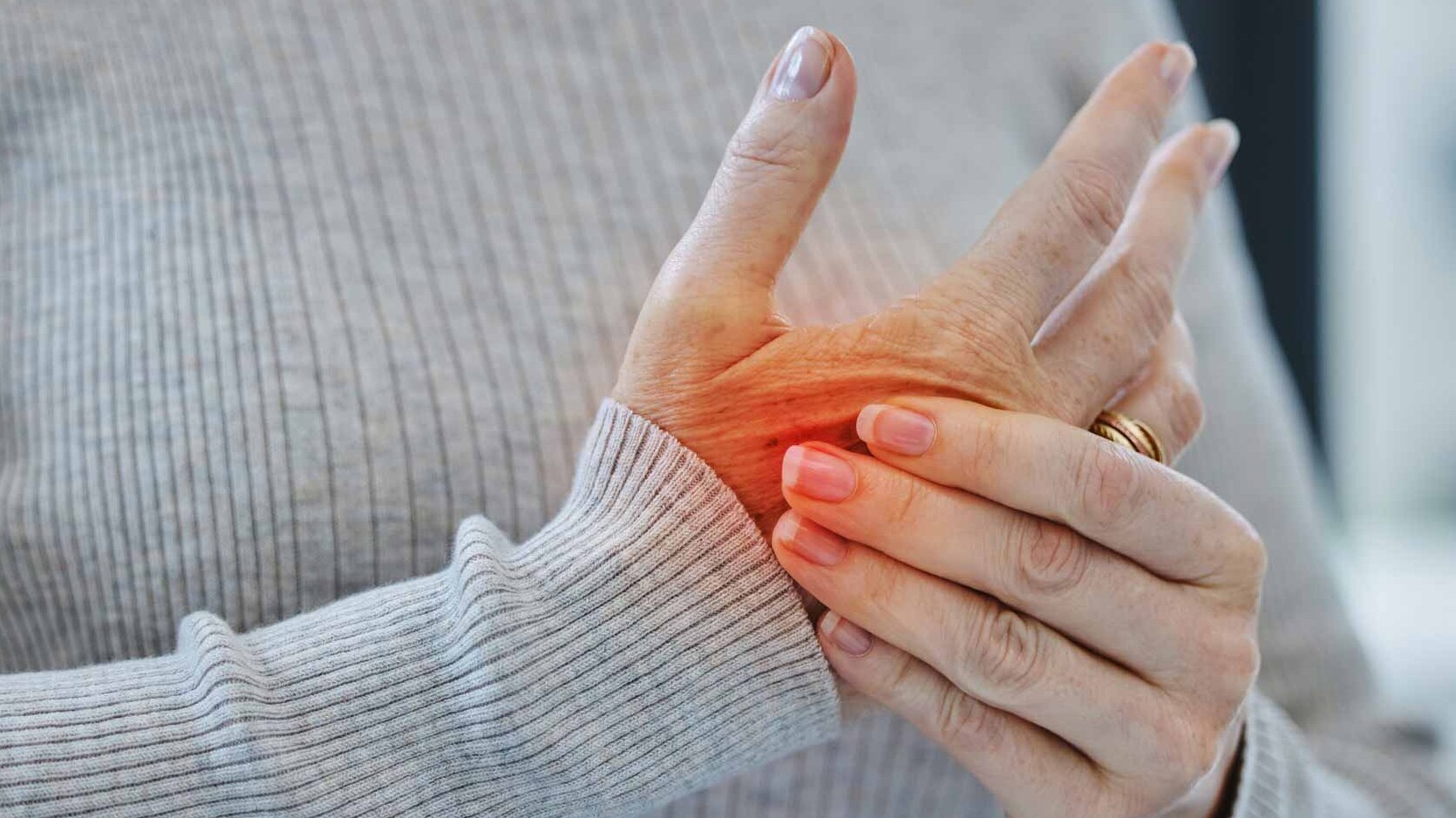 Eine Frau hält sich ihre schmerzende Hand