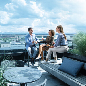 Um homem e duas mulheres estão num terraço e usam meias de compressão