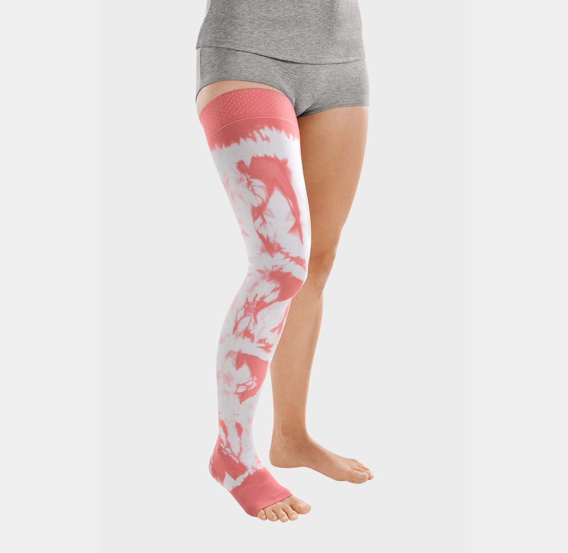 ScarComort Kompressionsstrumpf Rosa-Weiß Frau trägt einen rosafarbenen ScarComfort Fine Kompressionsstrumpf mit weißem Batik-Muster