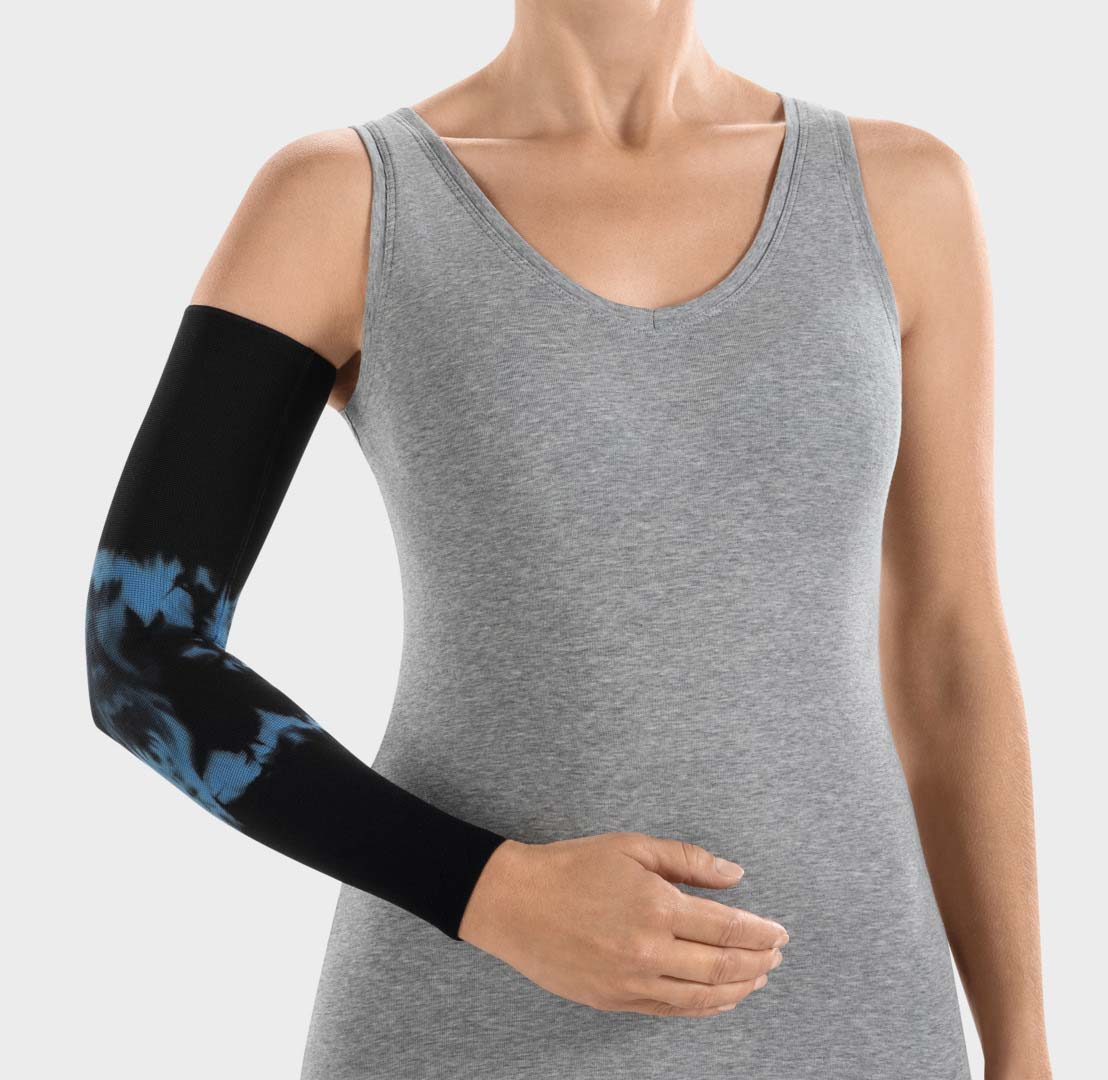 ScarComort Kompressionsärmel Batik Schwarz-Blau Frau trägt einen schwarzen ScarComfort Fine Kompressionsärmel mit blauem Batik-Muster