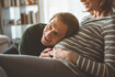 Mann hat den Kopf auf den Babybauch seiner Frau gelegt