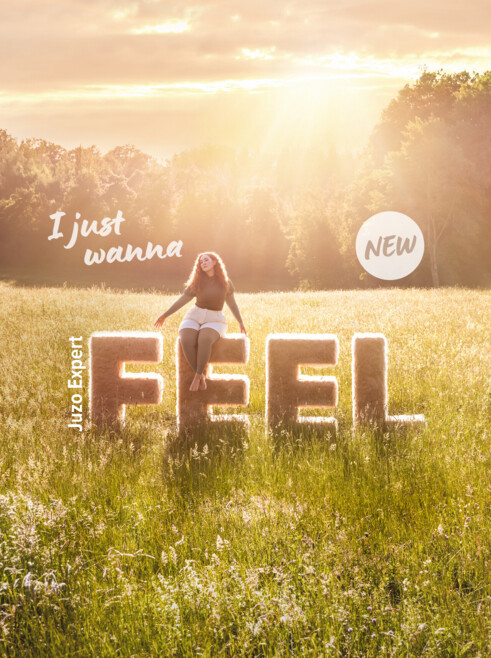 A woman is sitting on the letters ‘Feel’ and is wearing the Juzo Expert Feel