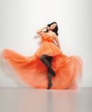 Frau mit Juzo Inspiration und Strumpfhose in Kakao und orangenem Kleid