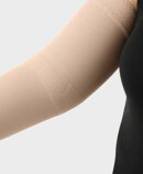 Donna indossa un bracciale compressivo Juzo con la zona funzionale Gomito